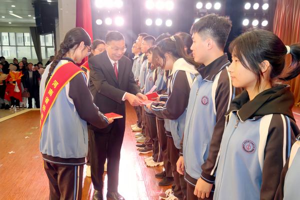 3郑州市第十九高级中学党委书记、校长梁寅峰为学生颁发《宪法》读本并致辞。